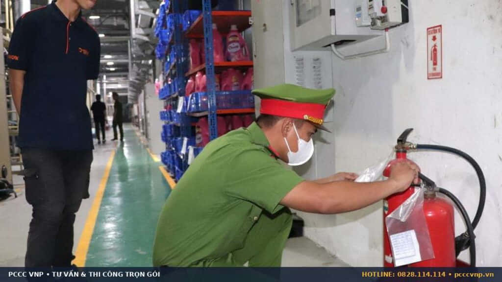 Cán bộ kiểm tra tem và áp suất bình chữa cháy tại nhà máy
